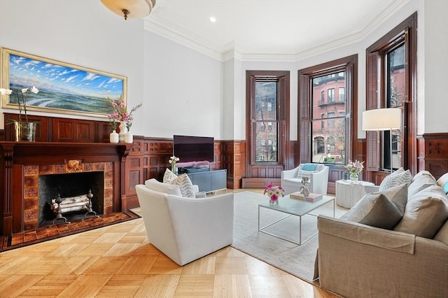 living room with a fireplace, wainscoting, ornamental molding, and recessed lighting
