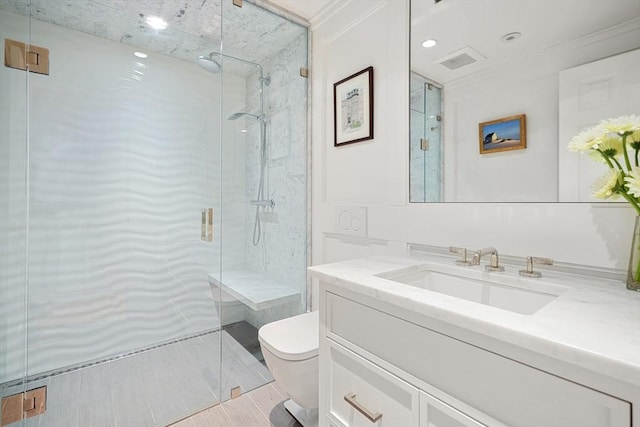 bathroom with toilet, a marble finish shower, and vanity