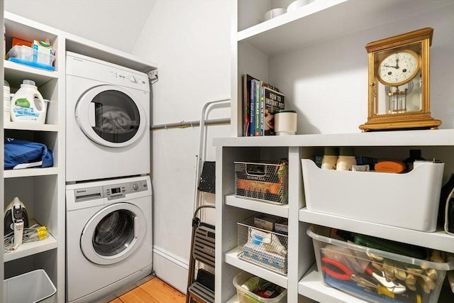 laundry area with estacked washer and dryer and light wood-style floors