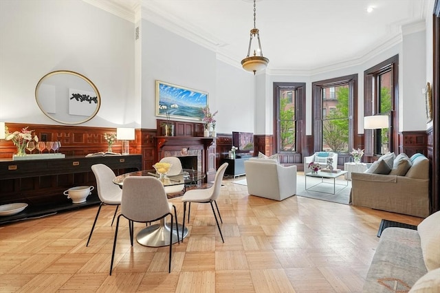 dining area with wainscoting, ornamental molding, and a fireplace