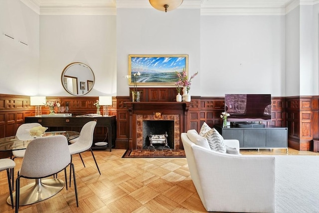 living area featuring a wainscoted wall and crown molding