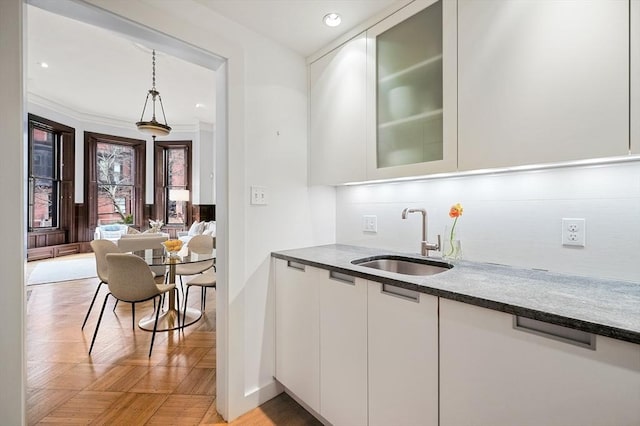 indoor wet bar with decorative backsplash, hanging light fixtures, recessed lighting, and baseboards