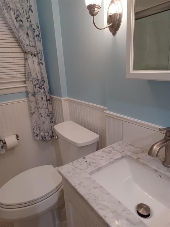 822 N Eastern Ave, Fall River, MA 02720 - bathroom with a wainscoted wall, toilet, and vanity