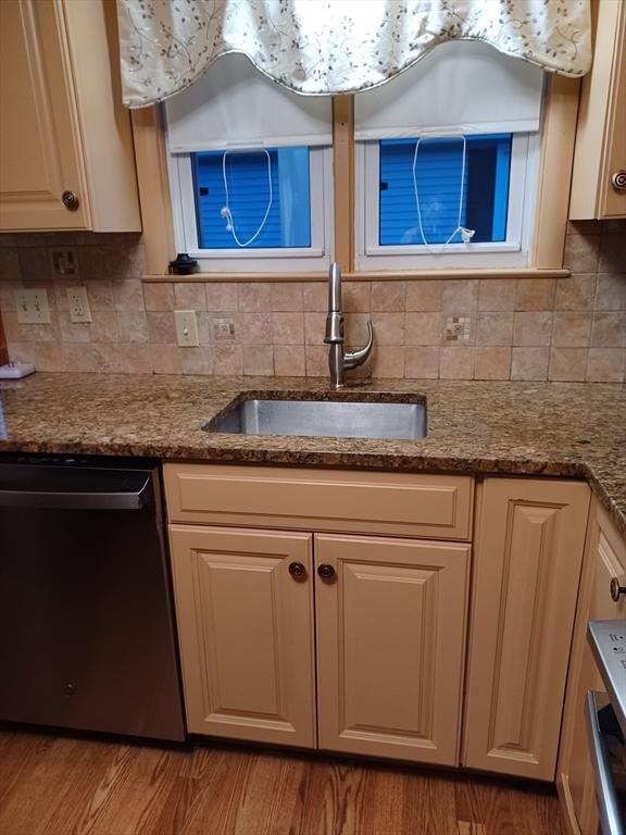 822 N Eastern Ave, Fall River, MA 02720 - kitchen featuring stainless steel dishwasher, a sink, decorative backsplash, wood finished floors, and stone counters