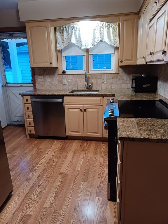 822 N Eastern Ave, Fall River, MA 02720 - kitchen featuring dishwasher, a sink, light wood-style flooring, and backsplash