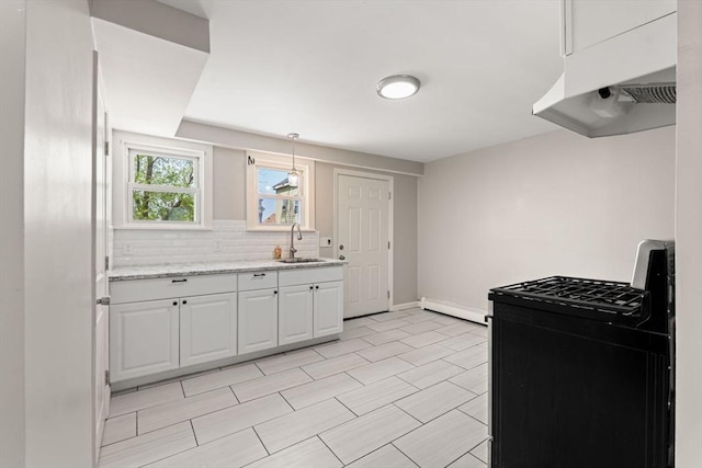 kitchen with black gas range, baseboard heating, white cabinets, a sink, and backsplash