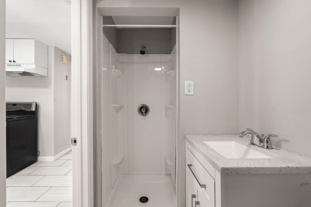full bathroom featuring vanity, baseboards, and a stall shower