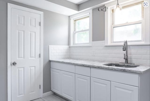 bathroom with backsplash, baseboards, and vanity