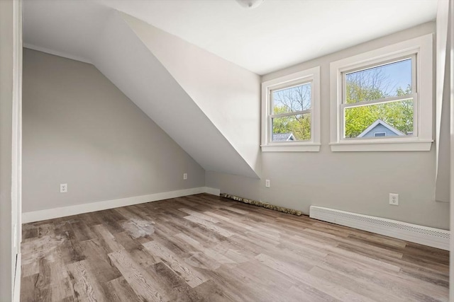 bonus room featuring baseboards, a baseboard radiator, wood finished floors, and vaulted ceiling