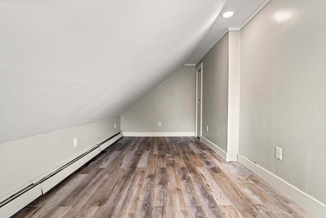 bonus room with wood finished floors, baseboards, baseboard heating, recessed lighting, and vaulted ceiling