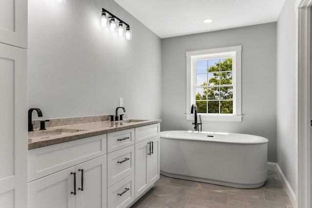 29 Sheppard Rd, Bourne, MA 02562 - full bathroom with a freestanding bath, double vanity, baseboards, and recessed lighting