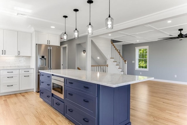 29 Sheppard Rd, Bourne, MA 02562 - kitchen featuring stainless steel appliances, light wood-type flooring, white cabinetry, blue cabinetry, and decorative backsplash