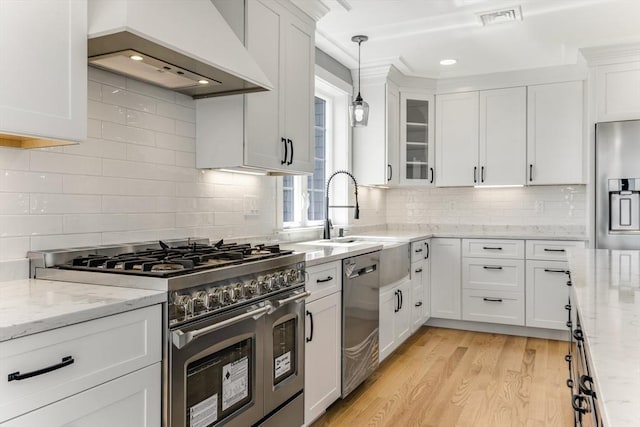 29 Sheppard Rd, Bourne, MA 02562 - kitchen with stainless steel appliances, premium range hood, a sink, white cabinetry, and light wood-style floors