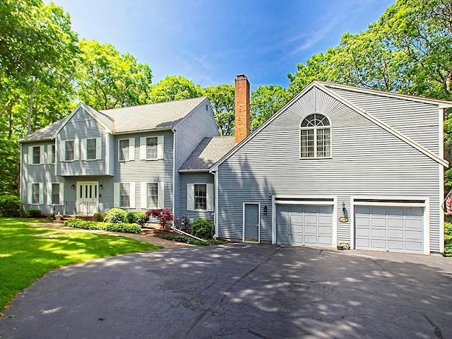 46 Clear Pond Rd, Falmouth, MA 02540 - view of front of house featuring asphalt driveway, a chimney, an attached garage, and a front lawn