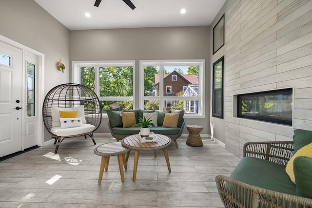 sitting room with a ceiling fan, wood finished floors, wooden walls, and recessed lighting