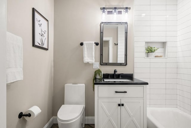 bathroom featuring toilet, vanity, shower / washtub combination, and baseboards