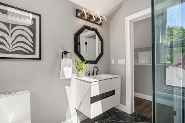 bathroom with marble finish flooring, baseboards, toilet, and vanity