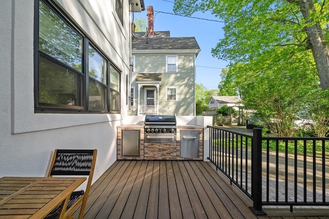 wooden deck with grilling area and an outdoor kitchen