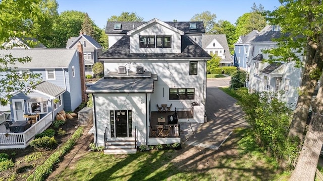 back of house with a wooden deck, stucco siding, and a residential view