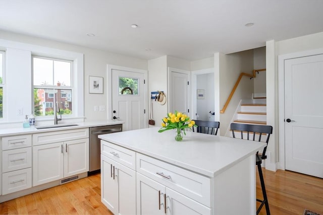 6 Macdonald Ter Unit E, Scituate, MA 02066 - kitchen with a sink, dishwasher, a kitchen breakfast bar, light wood-style floors, and light countertops