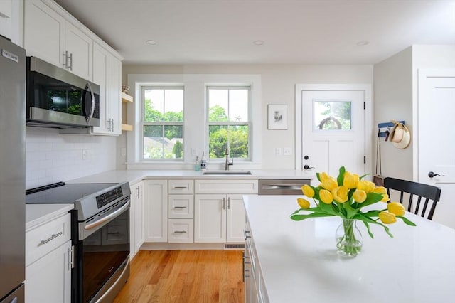 6 Macdonald Ter Unit E, Scituate, MA 02066 - kitchen featuring appliances with stainless steel finishes, a sink, light countertops, light wood-style flooring, and recessed lighting