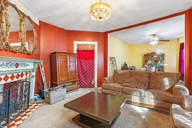 living room featuring ceiling fan with notable chandelier and a tile fireplace