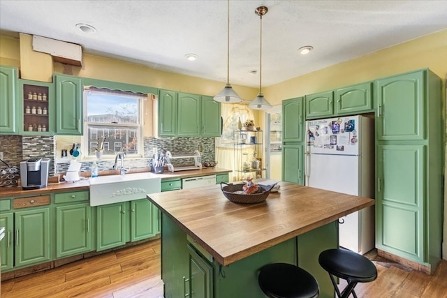 kitchen with sink, light wood-type flooring, and wooden counters