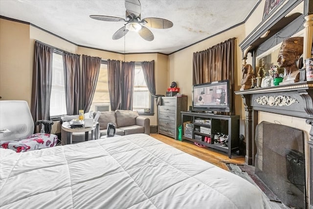 bedroom featuring hardwood / wood-style floors, a textured ceiling, ceiling fan, and ornamental molding