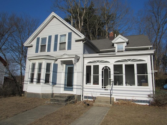 view of front of house with a chimney and a sunroom