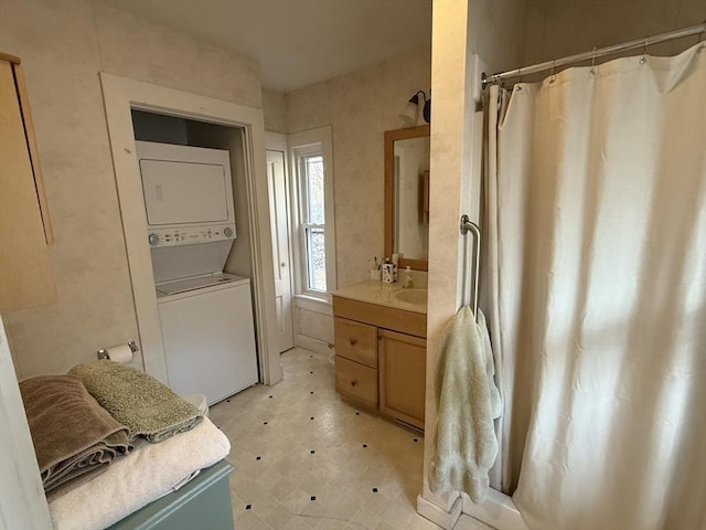 full bath with tile patterned floors, a shower with shower curtain, vanity, and stacked washing maching and dryer