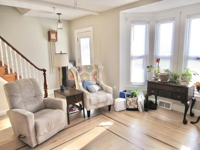 sitting room with visible vents, baseboards, wood finished floors, and stairs