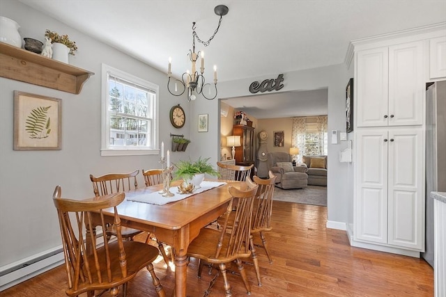 dining space featuring an inviting chandelier, baseboard heating, and light wood-type flooring