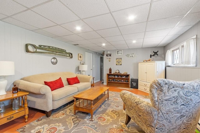living area with recessed lighting, wood finished floors, and a paneled ceiling