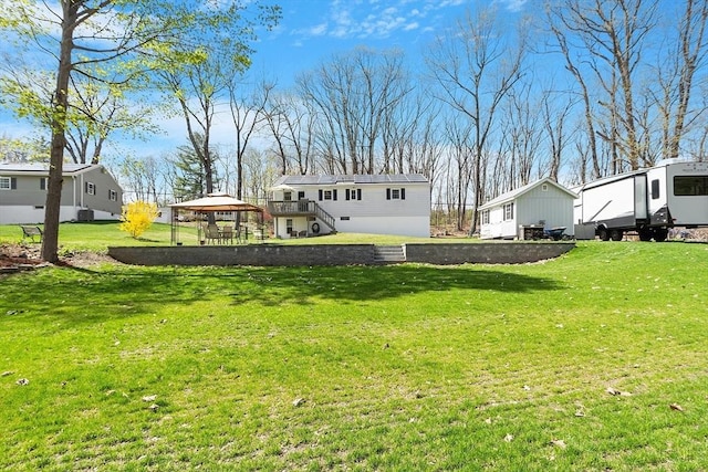 rear view of property featuring a gazebo and a yard