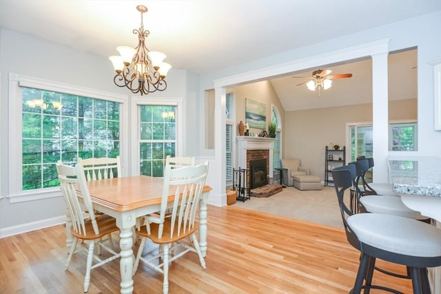 17 Stable Way, Medway, MA 02053 - dining space with a chandelier, light wood finished floors, a brick fireplace, lofted ceiling, and ceiling fan