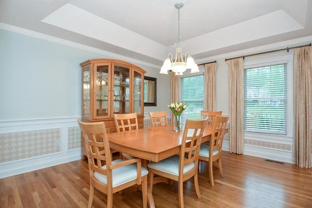 17 Stable Way, Medway, MA 02053 - dining space with a tray ceiling, a chandelier, light wood-type flooring, a wainscoted wall, and ornamental molding