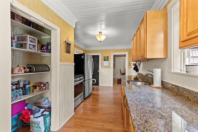85 Flint St, Salem, MA 01970 - kitchen featuring appliances with stainless steel finishes, wainscoting, light wood-style flooring, dark stone countertops, and crown molding