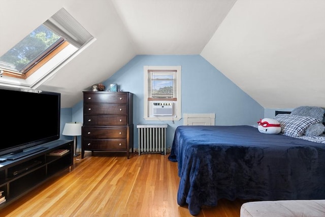 85 Flint St, Salem, MA 01970 - bedroom with radiator heating unit, cooling unit, wood finished floors, a skylight, and vaulted ceiling