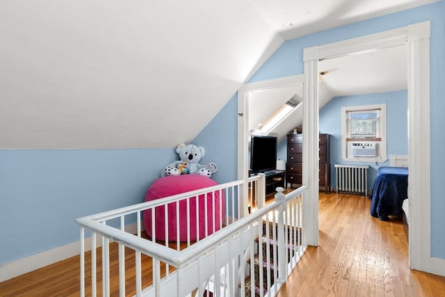 85 Flint St, Salem, MA 01970 - hall with vaulted ceiling, radiator, cooling unit, and wood finished floors