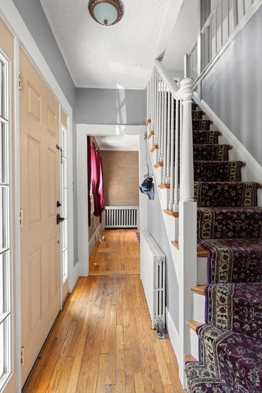 85 Flint St, Salem, MA 01970 - entryway with radiator heating unit, wood-type flooring, and stairs