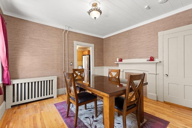 85 Flint St, Salem, MA 01970 - dining space with radiator, wood finished floors, crown molding, and wallpapered walls