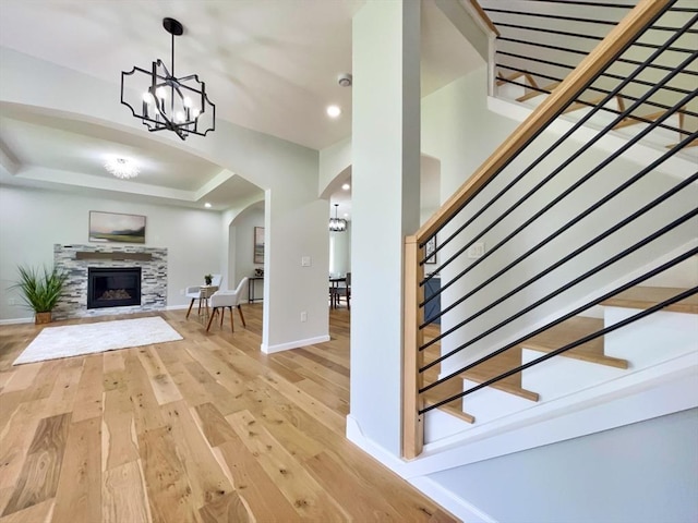 101 N Rd, Westfield, MA 01085 - living room featuring arched walkways, light wood-style flooring, stairway, a chandelier, and a raised ceiling