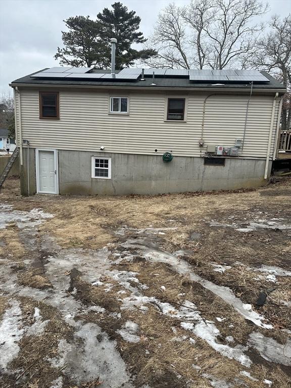 back of property featuring solar panels