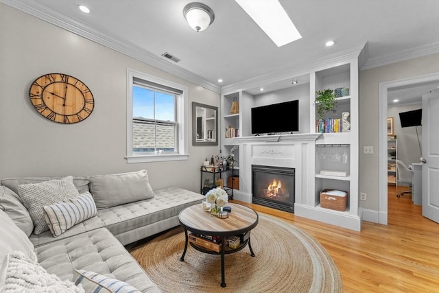 10 Mitchell St Unit 3, Boston, MA 02127 - living room with light wood-style floors, a glass covered fireplace, crown molding, built in features, and recessed lighting