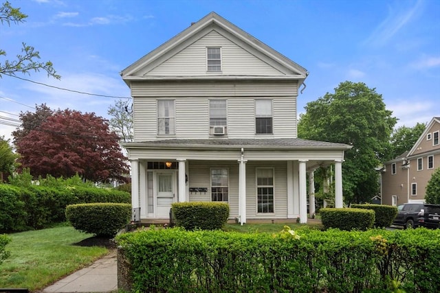 greek revival inspired property featuring a porch and a front lawn