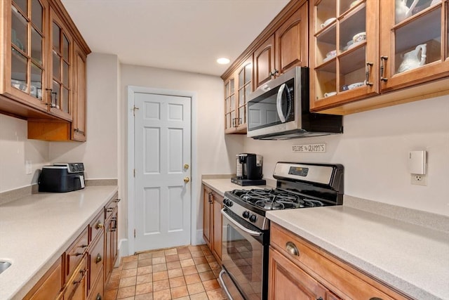 kitchen with stainless steel appliances, light countertops, brown cabinets, and recessed lighting