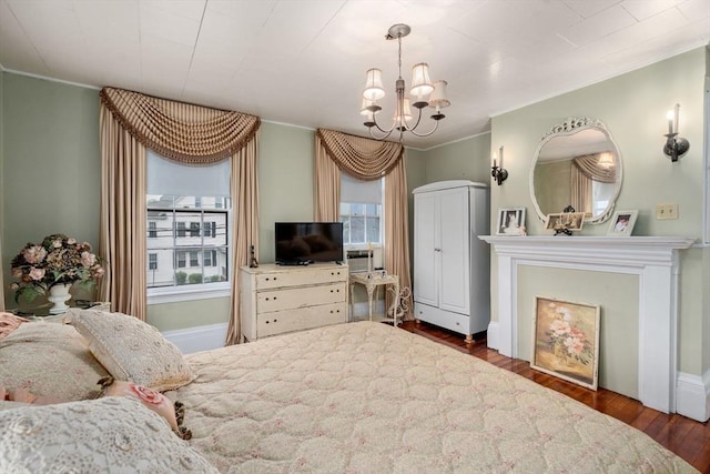 bedroom with crown molding, a chandelier, and wood finished floors