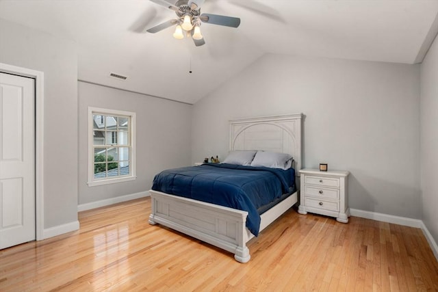 bedroom featuring baseboards, light wood finished floors, vaulted ceiling, and ceiling fan
