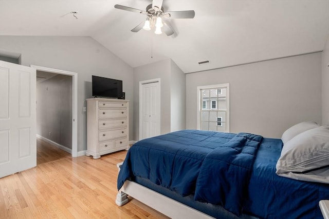 bedroom featuring vaulted ceiling, light wood finished floors, a ceiling fan, a closet, and baseboards