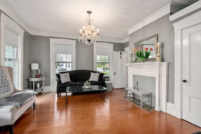 sitting room featuring a chandelier, wood finished floors, crown molding, and a fireplace